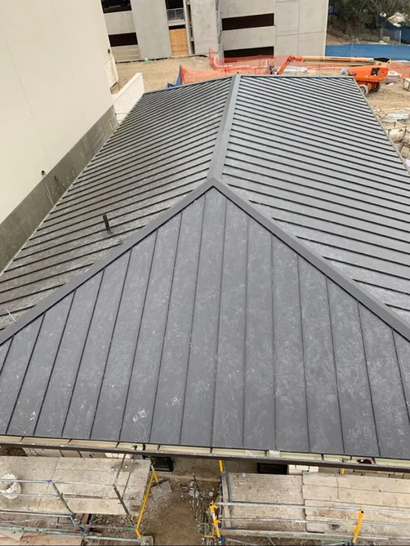 Commercial metal roof construction with crane equipment in Live Oak